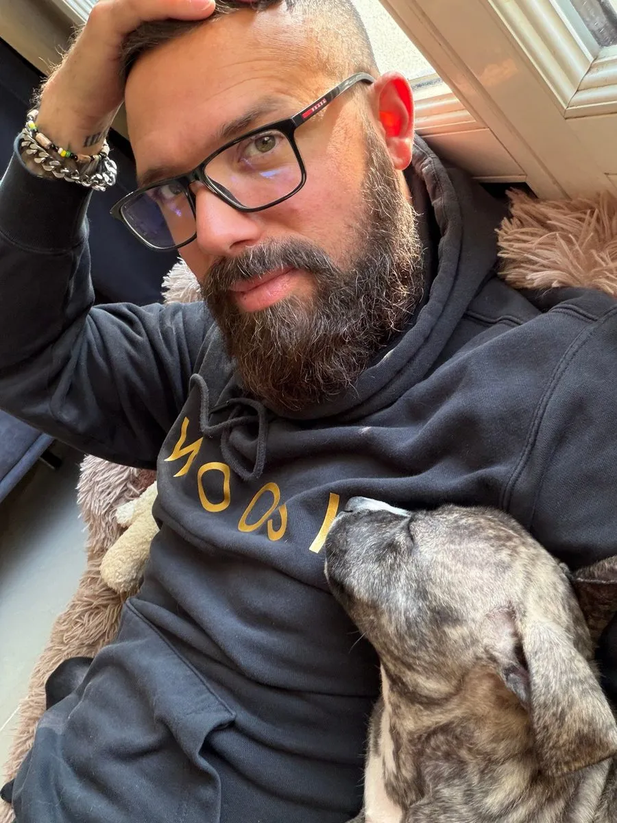 Kevin allongé, un chiot bringé endormi contre lui